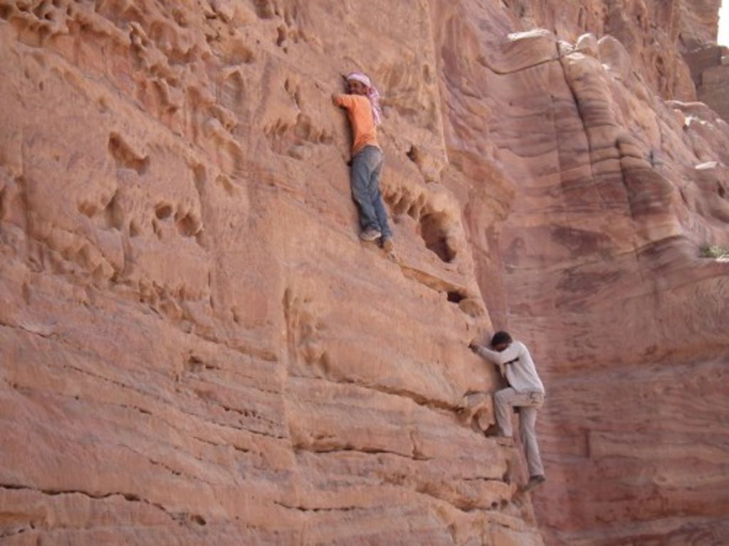 Fig. 81: Workmen trying to climb the steep tomb facade at Khubta.