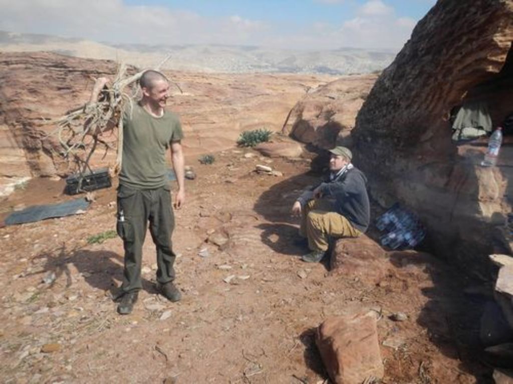 Fig. 12: Will Kennedy (left) returns from collecting fire wood, while Marco Dehner (right) is guarding the water bottles