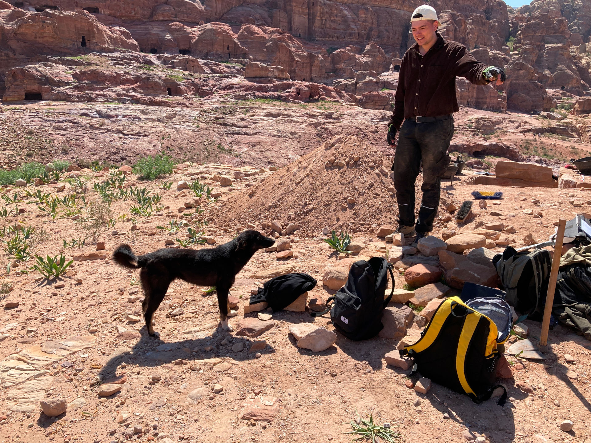 Fig. 21: A dog from the nearby cave is visiting. Ernst Tolksdorff tries to keep him away from the biscuits (photo: André Barmasse).